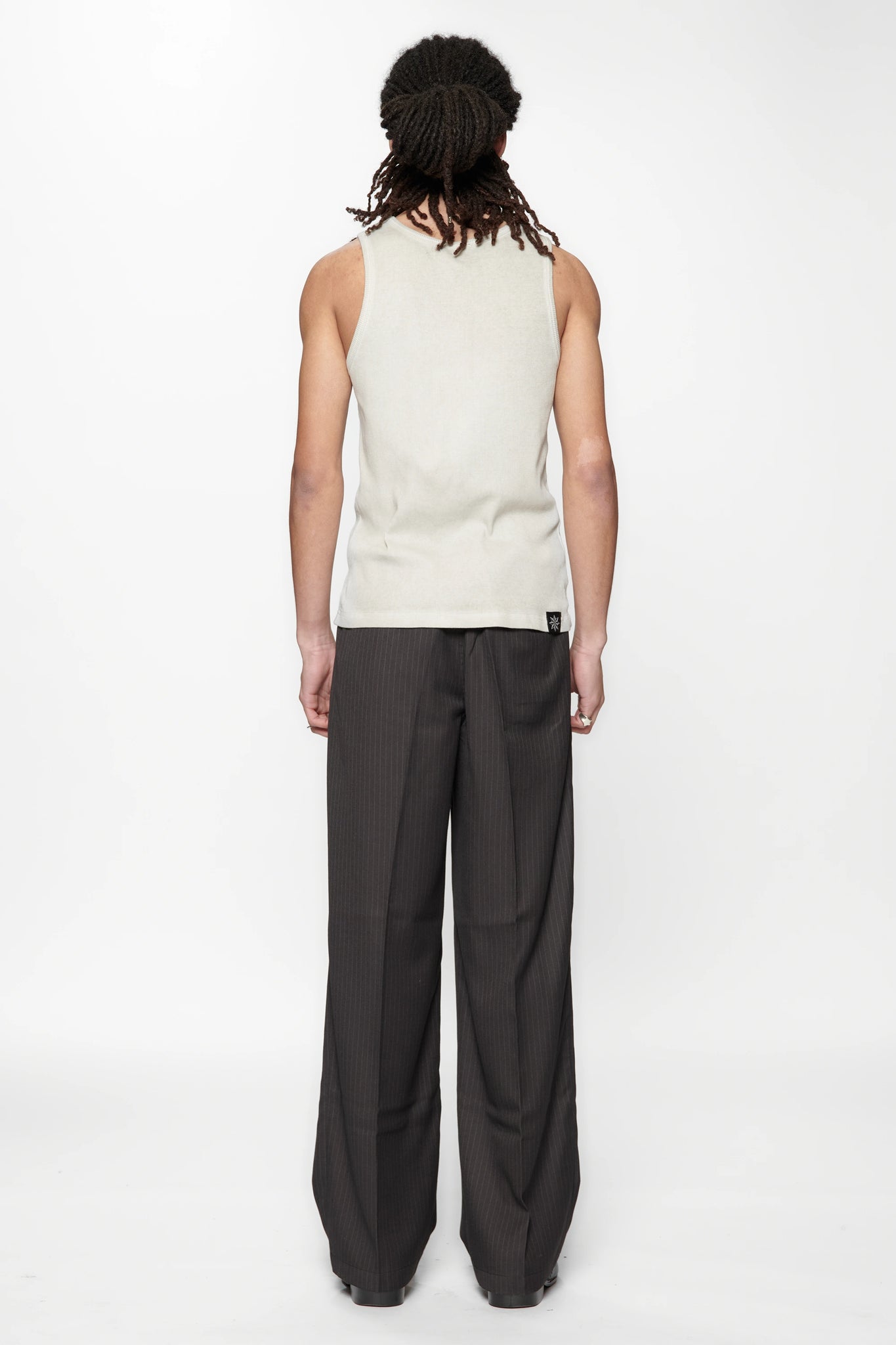 Behind view of a person wearing a beige tank top and Limit Suit Trouser Classic Pinstripe by Beach Brains