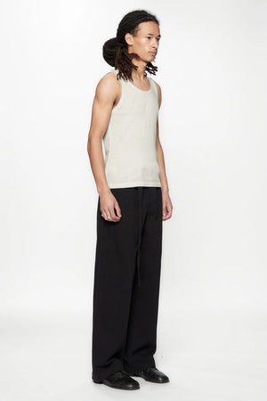Side view of a person wearing a beige tank top and Pleated Work Pants in Black by Beach Brains