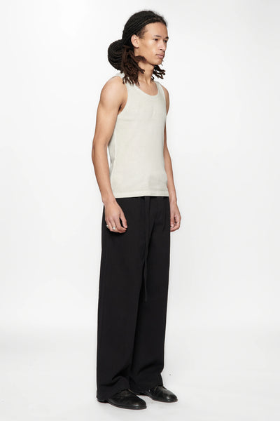 Side view of a person wearing a beige tank top and Pleated Work Pants in Black by Beach Brains