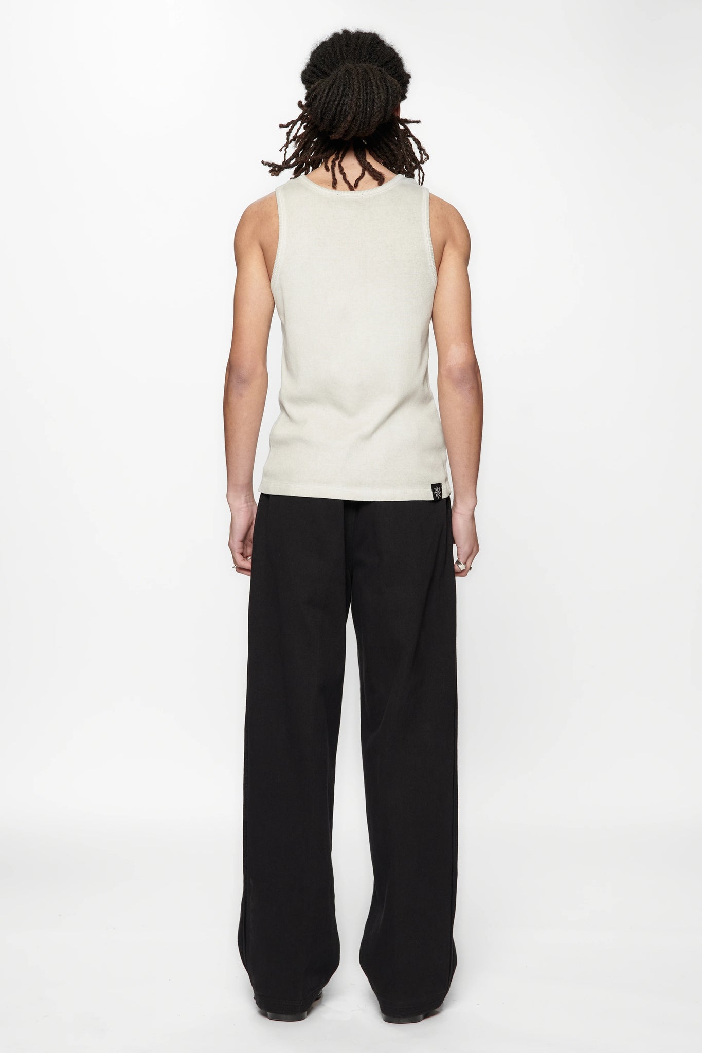 Behind view of a person wearing a beige tank top and Pleated Work Pants in Black by Beach Brains
