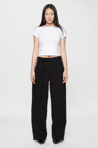 A woman wearing a white crop top and Pleated Work Pants in Black by Beach Brains