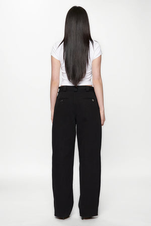 Behind view of a woman wearing a white crop top and Pleated Work Pants in Black by Beach Brains