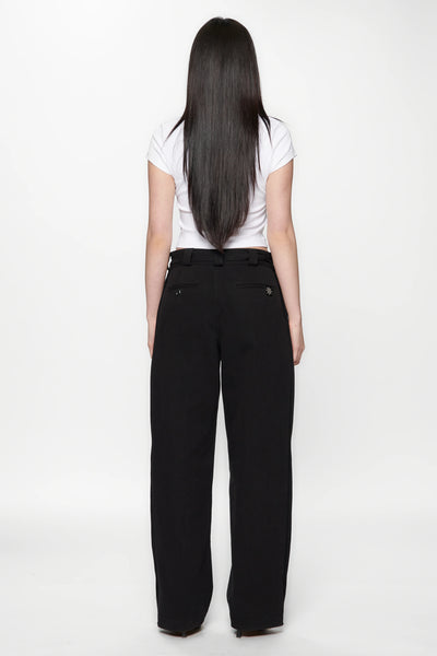 Behind view of a woman wearing a white crop top and Pleated Work Pants in Black by Beach Brains